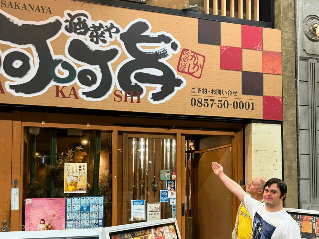 Gareth pointing up at a sign in Japanese. 