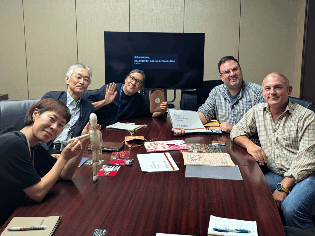 Ellis and Ben sat around a table during a meeting with representatives from another organisation.